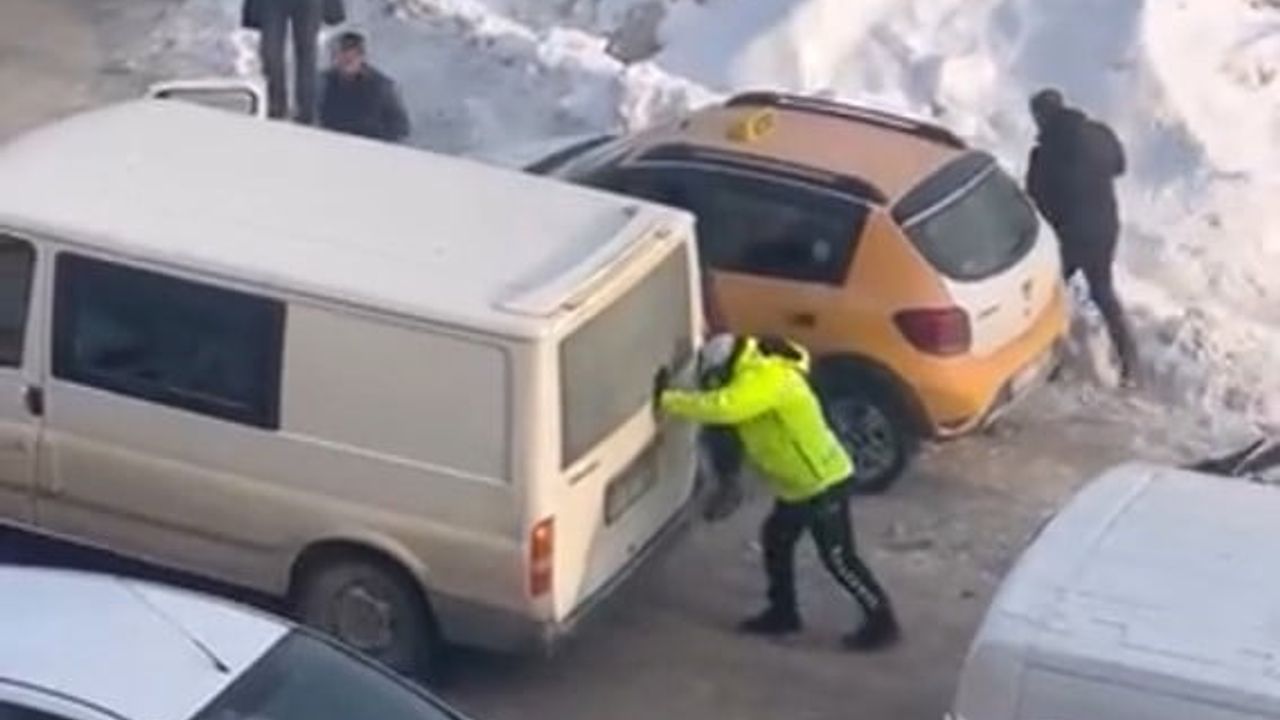 Yüksekova'da trafik polisi buzlu zeminde mahsur kalan aracı itti