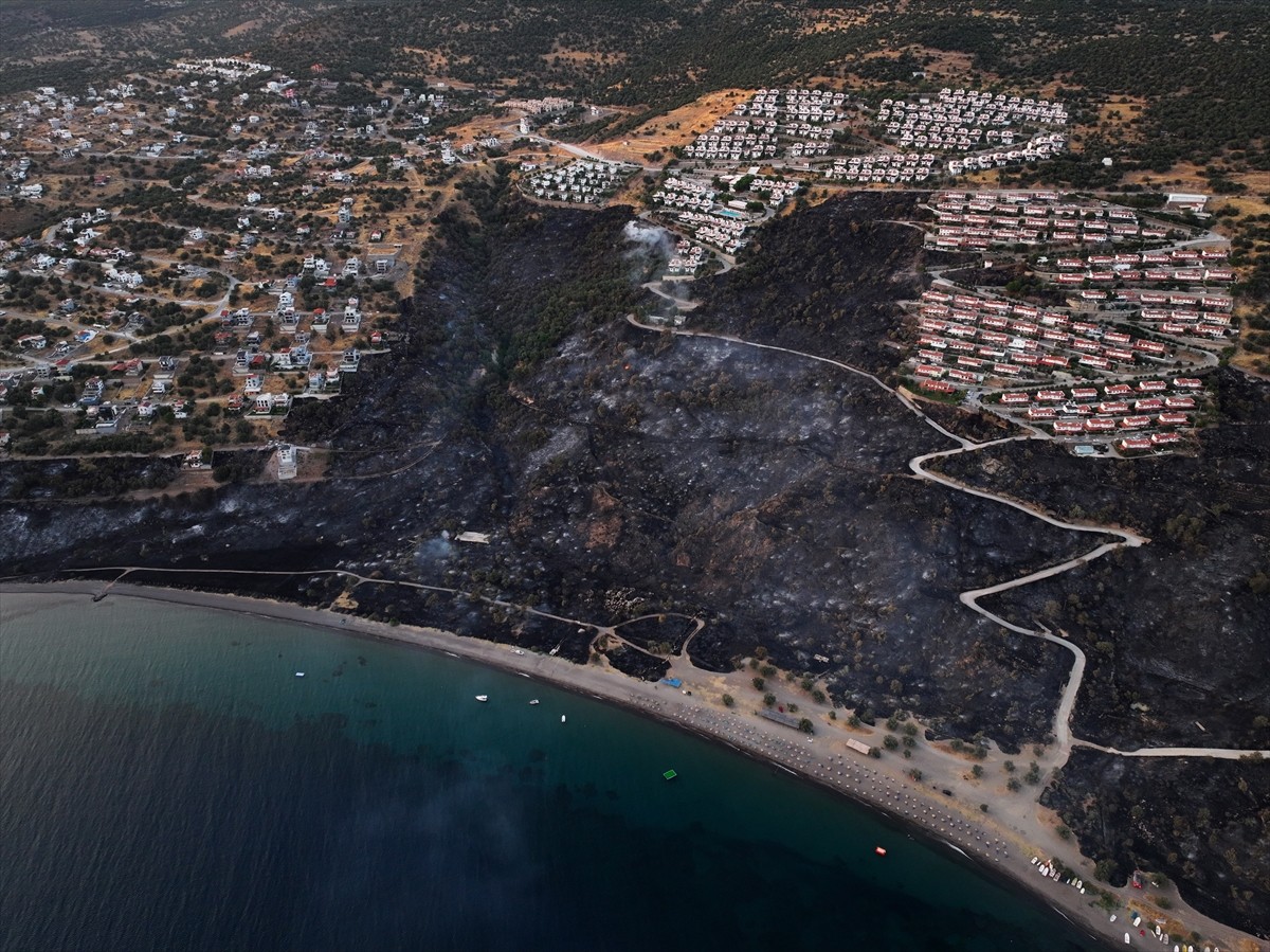 İzmir'in Dikili ilçesinde ormanlık alanda başlayan ve yerleşim yerlerine yaklaşan yangına havadan...