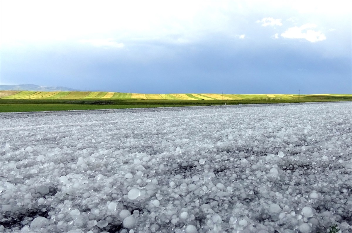 Kars'ta sağanak sonrası yağan dolu, kara yolunu ve evlerin bahçelerini beyaz örtüyle kapladı.