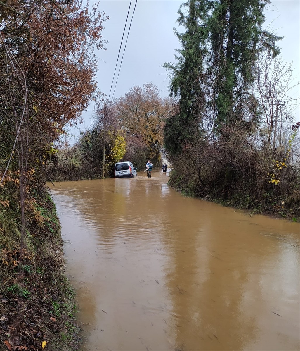 Muğla'nın Menteşe ilçesinde sağanak nedeniyle su biriken yolda araçlarında mahsur kalan 2'si çocuk...
