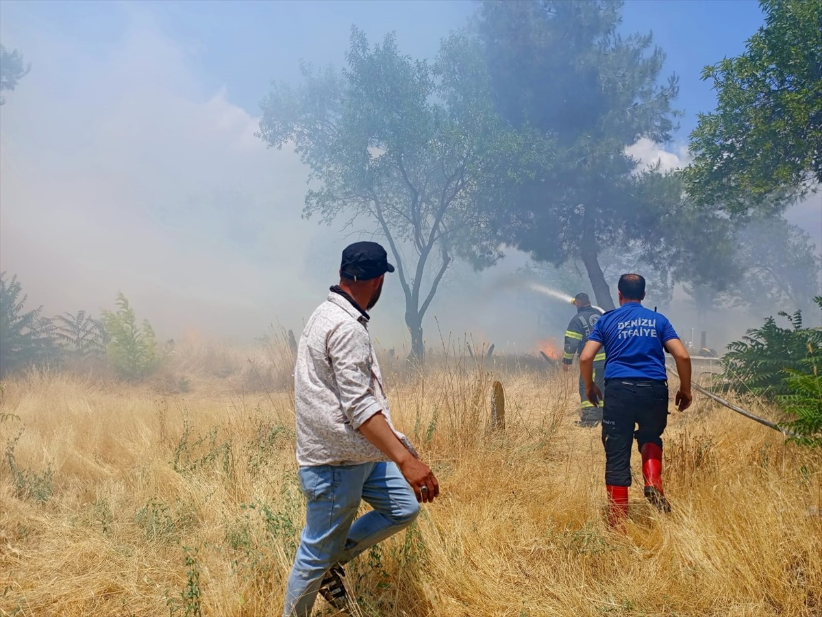 Denizli'nin Çivril ilçesindeki mezarlıktaki otluk alanda çıkan yangın, itfaiye ekiplerinin...
