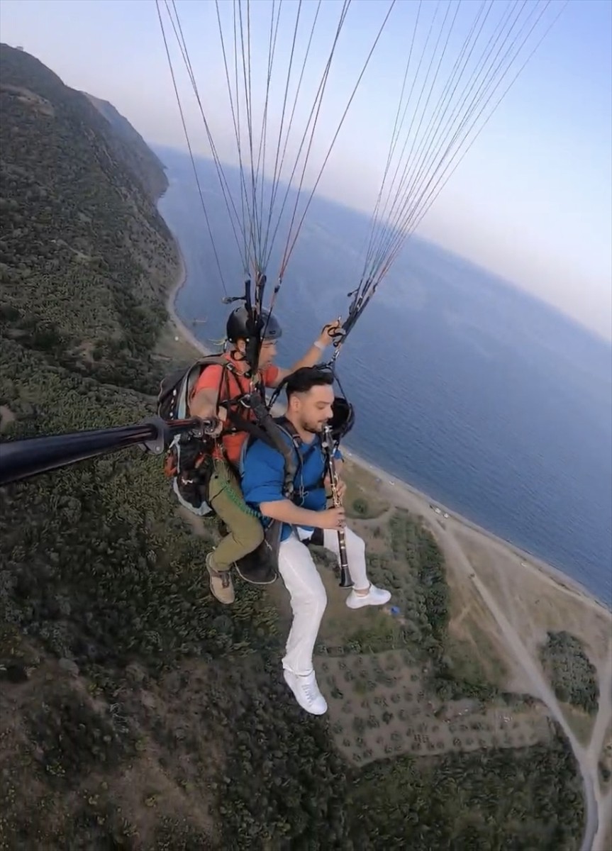 Tekirdağ'ın Şarköy ilçesine gezmeye gelen Yaşar Gümüş, yamaç paraşütüyle uçarken klarnet...