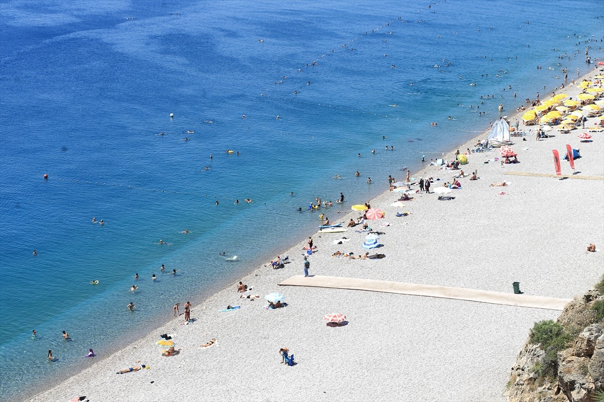 Antalya'da sıcak hava ve nemden bunalan yerli ve yabancı turistler, sahillerde ve gölgelik...