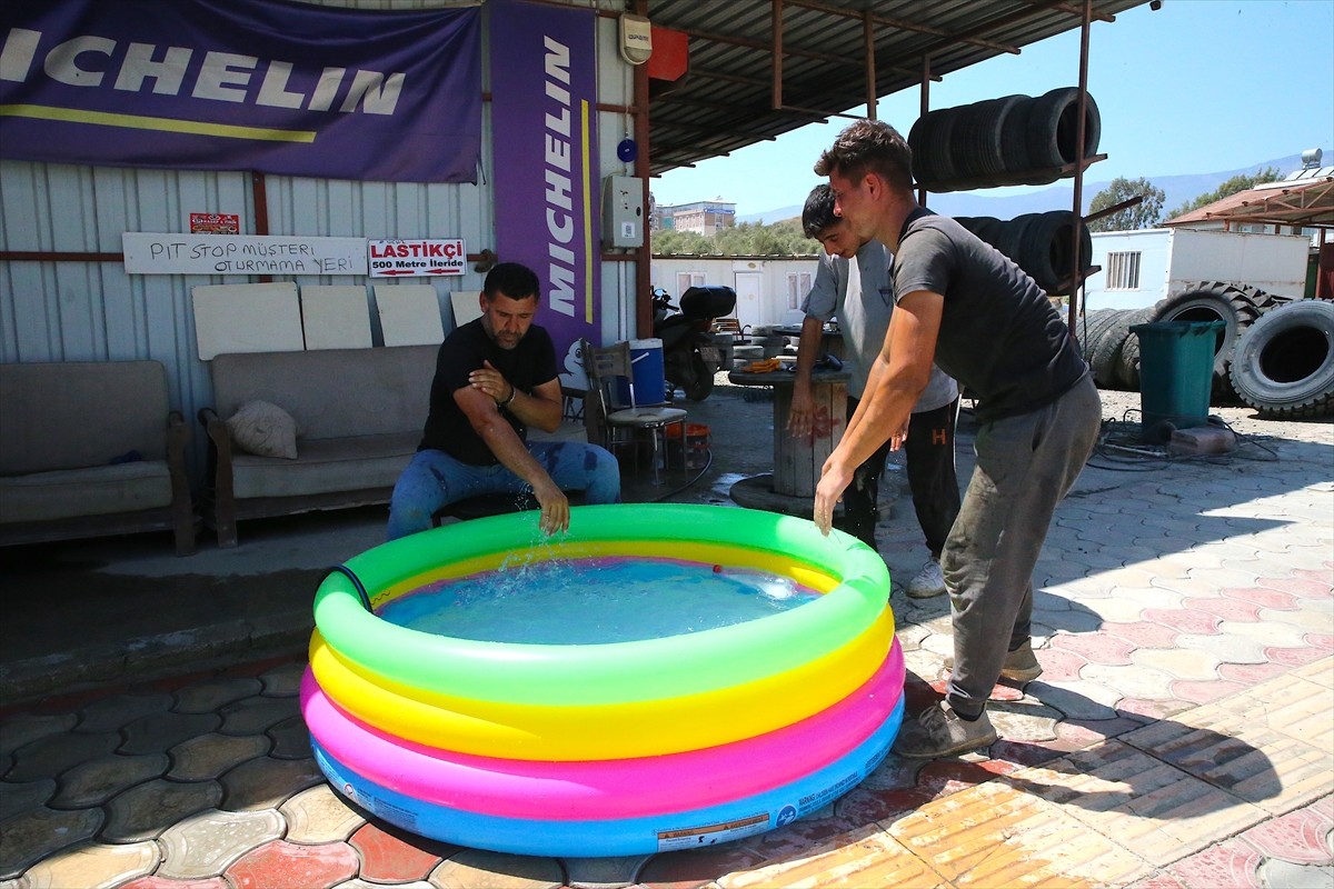 Hatay'ın merkez Antakya ilçesinde sıcaktan bunalan bir esnaf, çözümü şişme havuzda buldu. 
