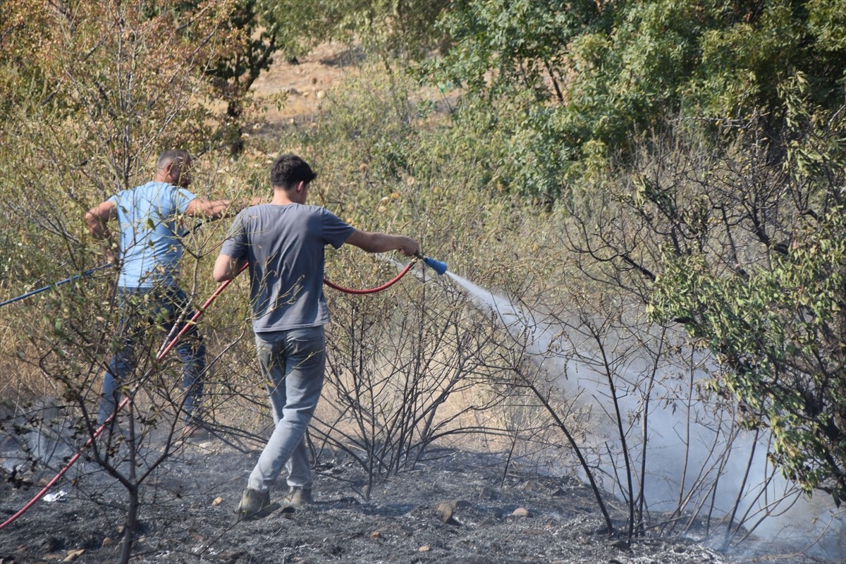 Manisa'nın Turgutlu ilçesinde tarım arazisinde başlayıp makilik alana sıçrayan yangın, ekiplerin...