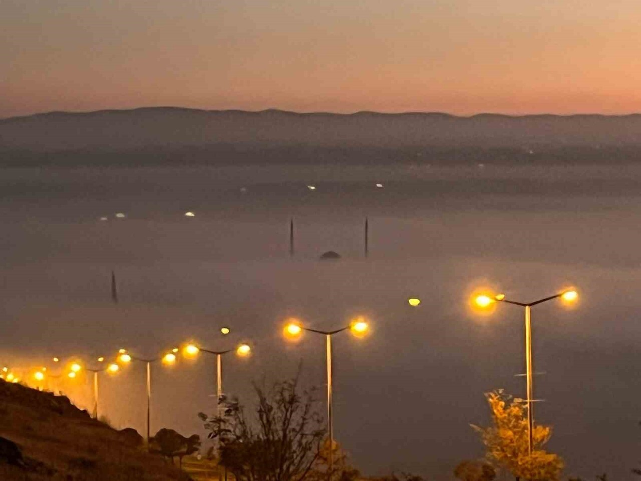 BATMAN’DA AKŞAM SAATLERİNDE ETKİLİ OLAN YOĞUN SİS, GÜN BATIMININ KIZILLIĞIYLA BİRLEŞEREK ŞEHRİN...