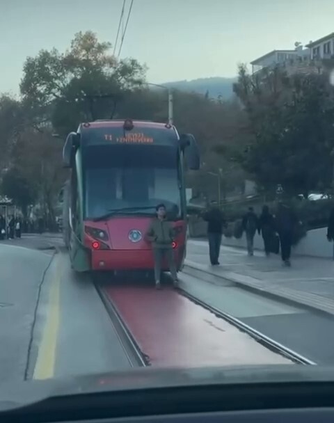 BURSA’NIN OSMANGAZİ İLÇESİNDE SEYİR HALİNDEKİ TRAMVAYIN ARKASINA OTURARAK YOLCULUK YAPAN ÇOCUK...