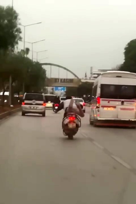 ADANA’DA BİR KİŞİNİN MOTOSİKLETİ ÖNCE ÇÖMELEREK, SONRA DA YATARAK SÜRMESİ GÖRENLERİ HAYRETE...