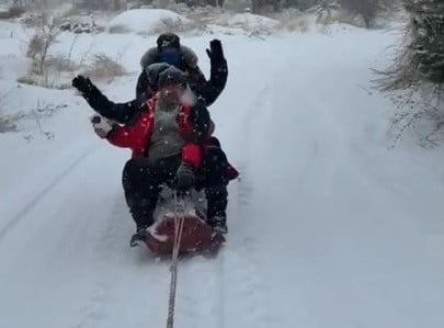 MALATYA'NIN AKÇADAĞ İLÇESİNDE TRAKTÖRÜN ARKASINA BAĞLANAN KÜTÜK ÜZERİNDE KARDA 'SÖRF' YAPAN...