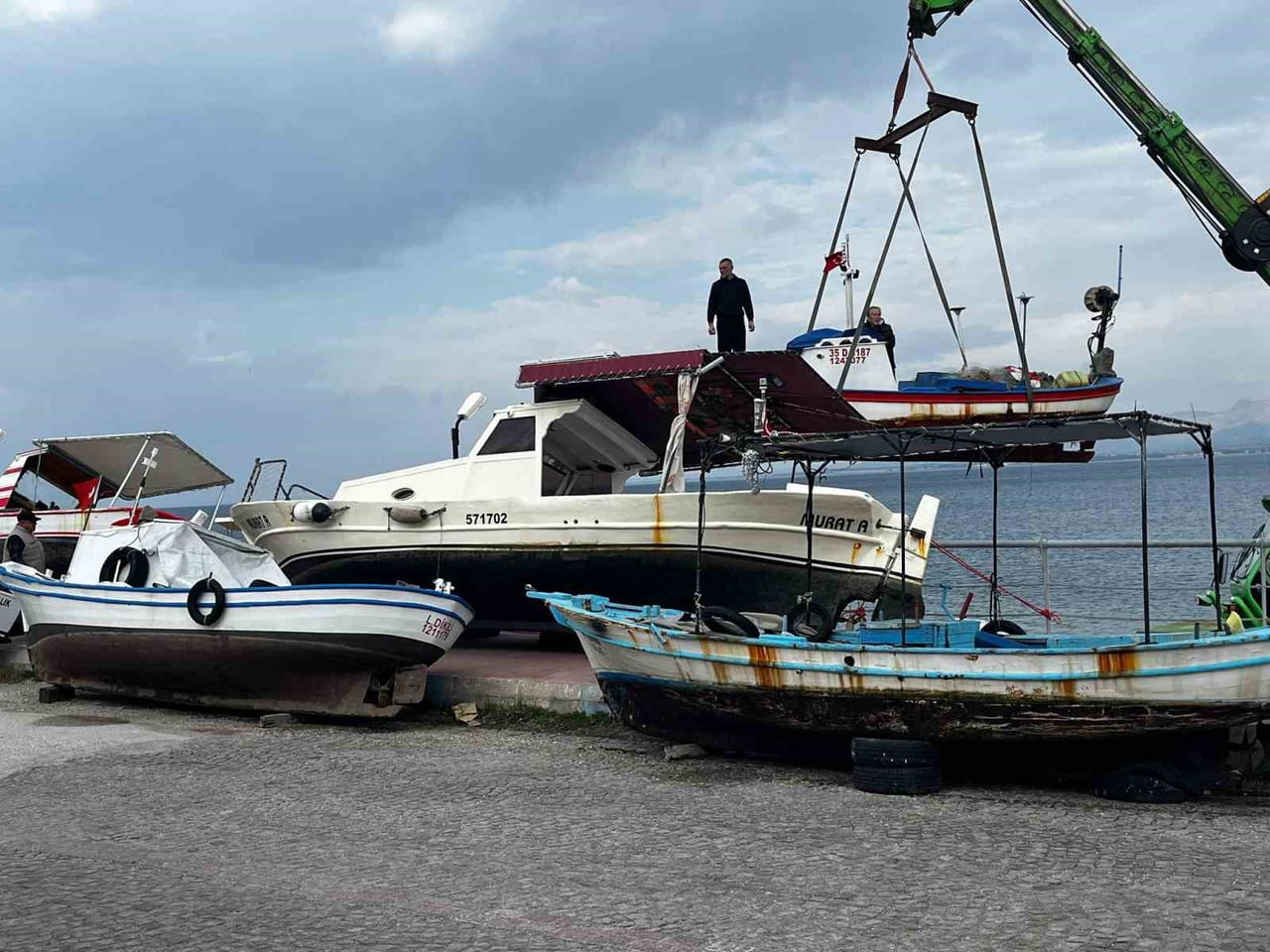 İZMİR'DE BUGÜN BEKLENEN FIRTINAYA KARŞI DİKİLİ İLÇESİNDE BALIKÇI TEKNELERİ VİNÇLER YARDIMIYLA...